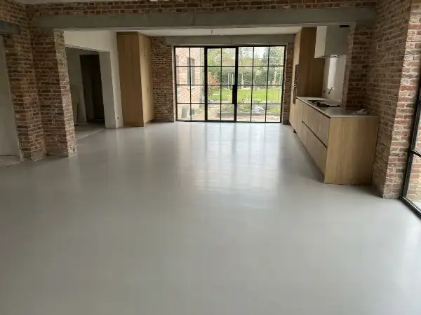Pas gegoten lichtgrijze gietvloer in een open keuken